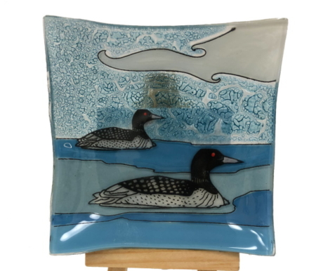 Two loons on a blue background small glass plate