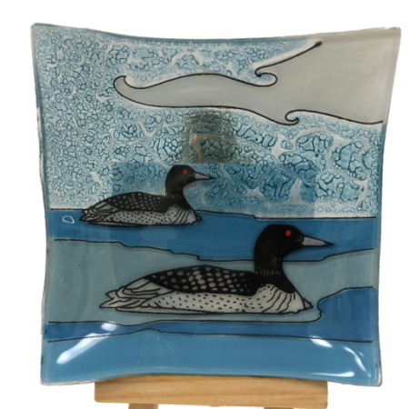 Two loons on a blue background small glass plate